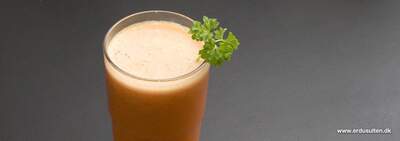 Rød morgenjuice med cremet skum i glas, synlige stykker gulerod, appelsin, bær, æble, ananas og banan.