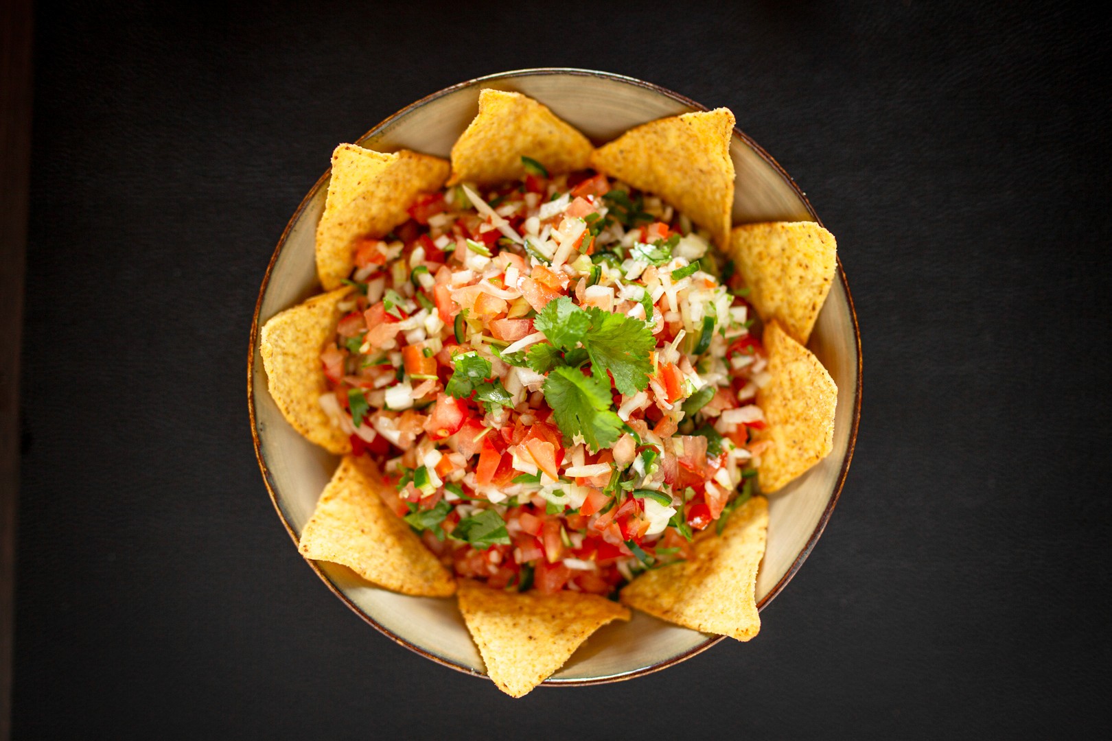 Frisk, farverig pico de gallo med tomat, løg, koriander og jalapeno, fint hakket og omgivet af tortilla chips.