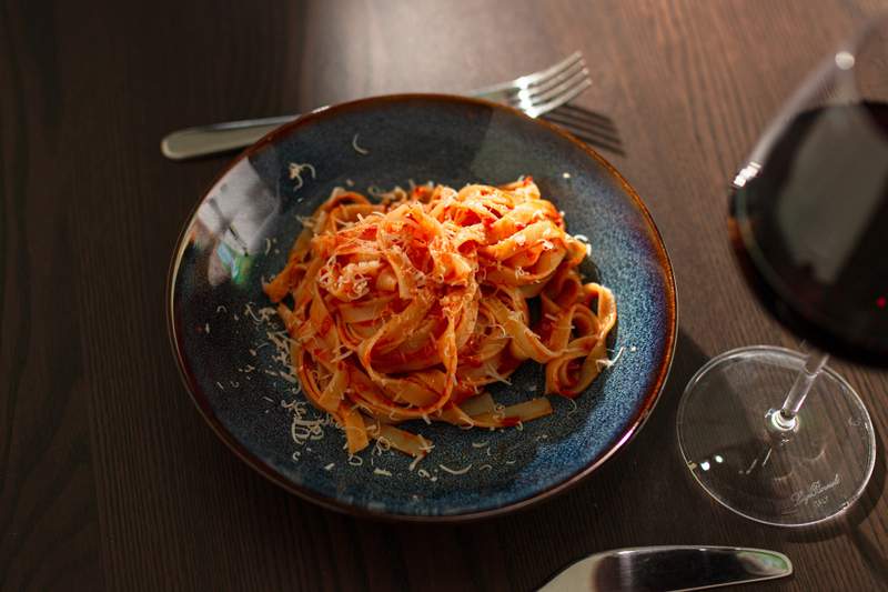 Billede af tomatsauce med smør på tallerken med rødvin ved siden af