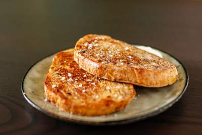 Gyldenbrune toastskiver med smør og synlige saltkrystaller, sprøde kanter og saftig midte.